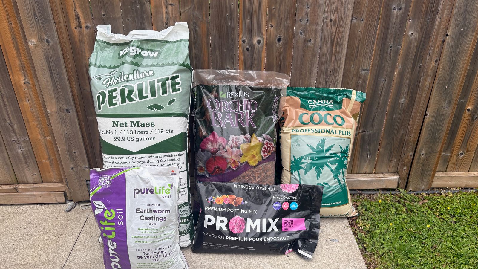 A number of soil amendments pictured together: perlite, orchid bark, coco coir, potting mix, and worm castings
